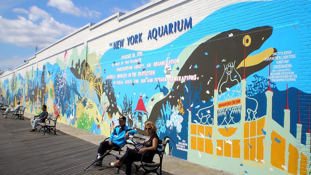 a man and woman sitting on benches outside of a building