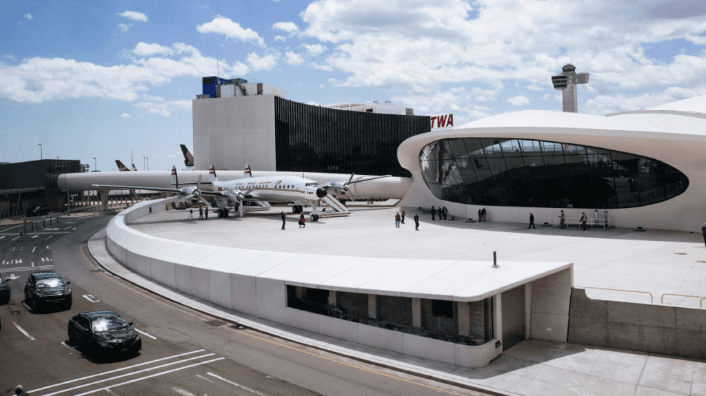 a group of people standing around a building with airplanes