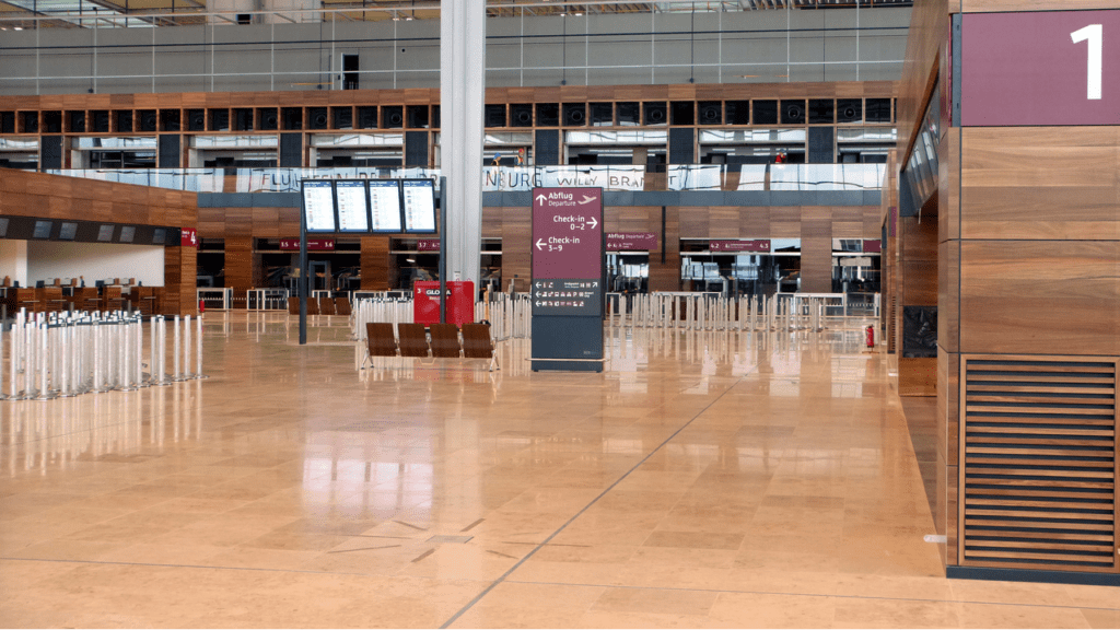 a large empty airport with signs and seats