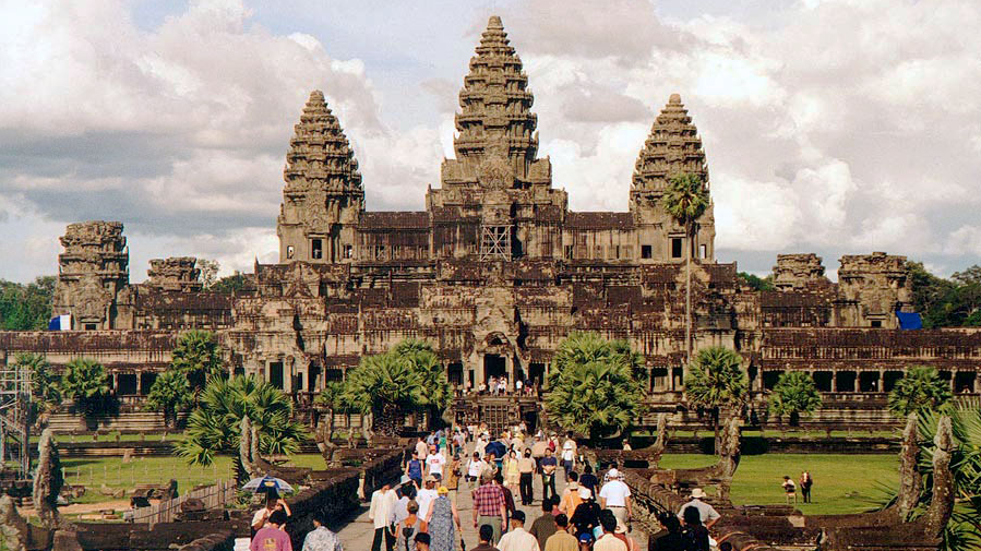 a group of people walking in front of Angkor Wat