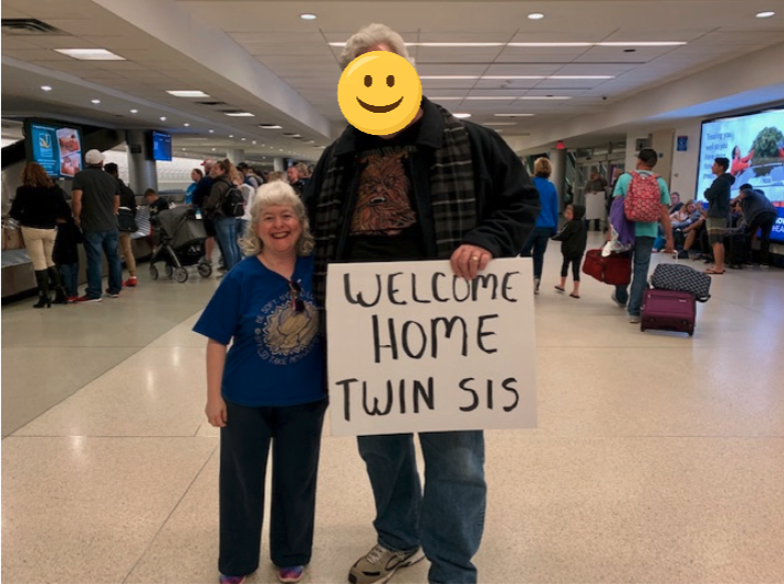 a man holding a sign with a smiling face