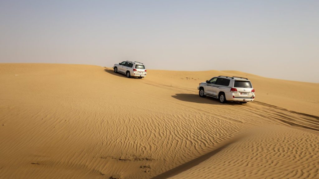 two cars driving in a desert