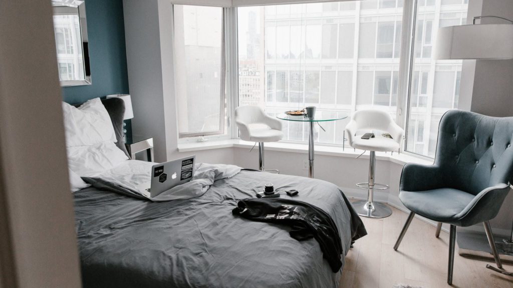 a bedroom with a laptop on a bed