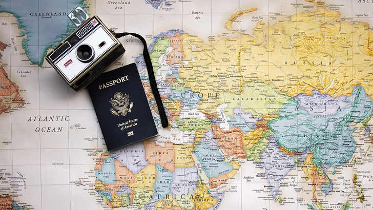 a camera and passport on a map