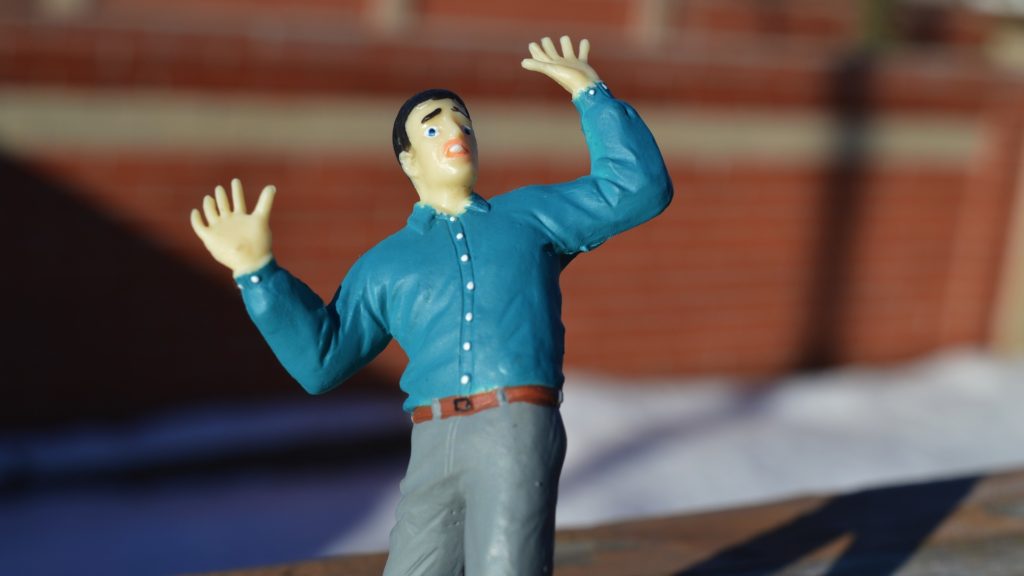 a toy figurine of a man with his hands up