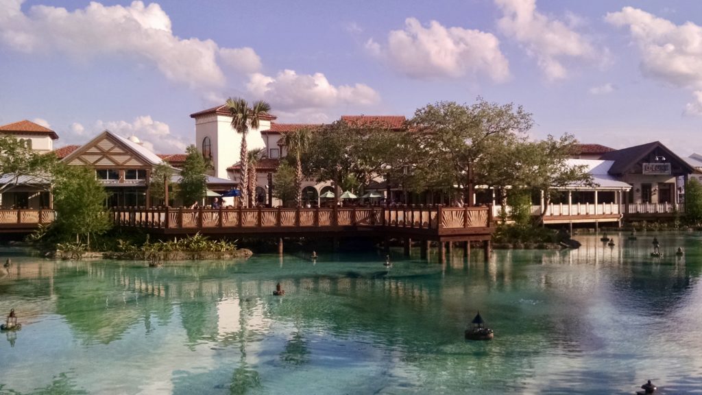 a bridge over water with trees and buildings in the background