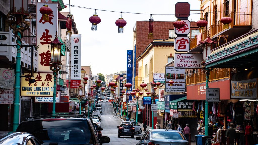 a street with cars and lanterns