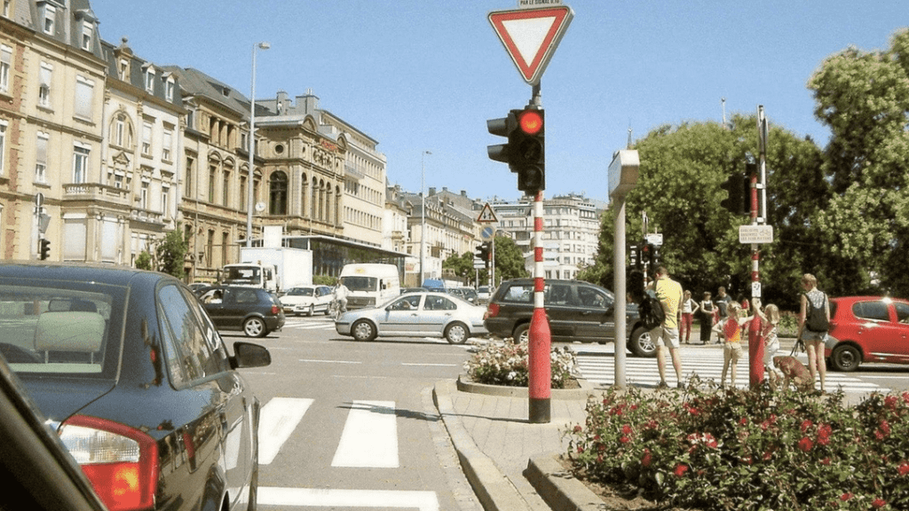 a street with cars and people walking on the street