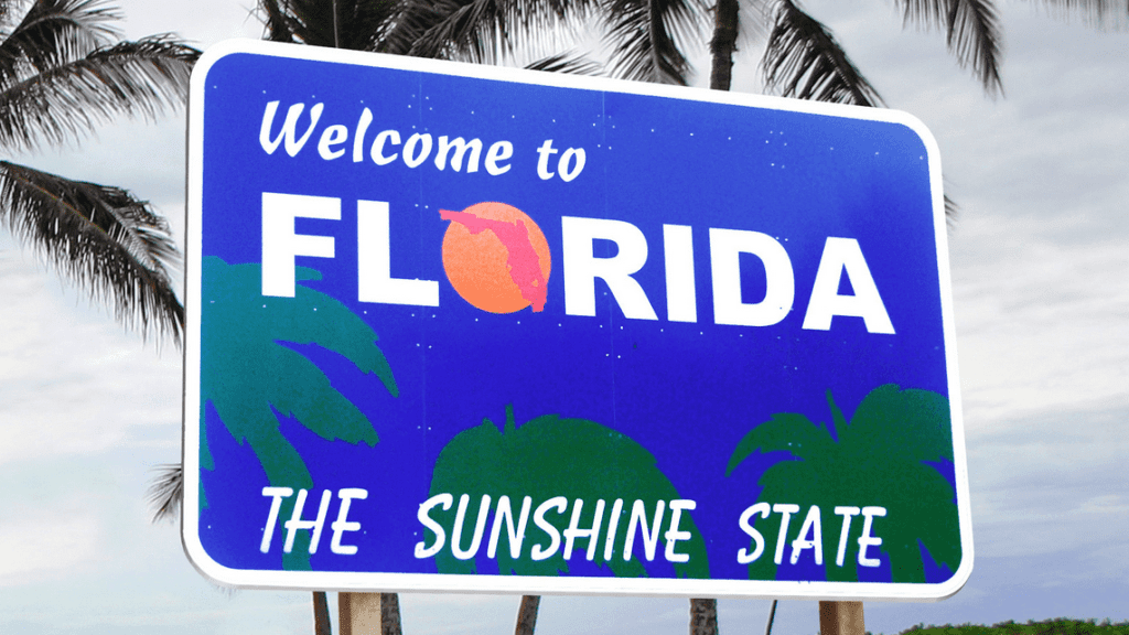 a blue sign with palm trees and a sun