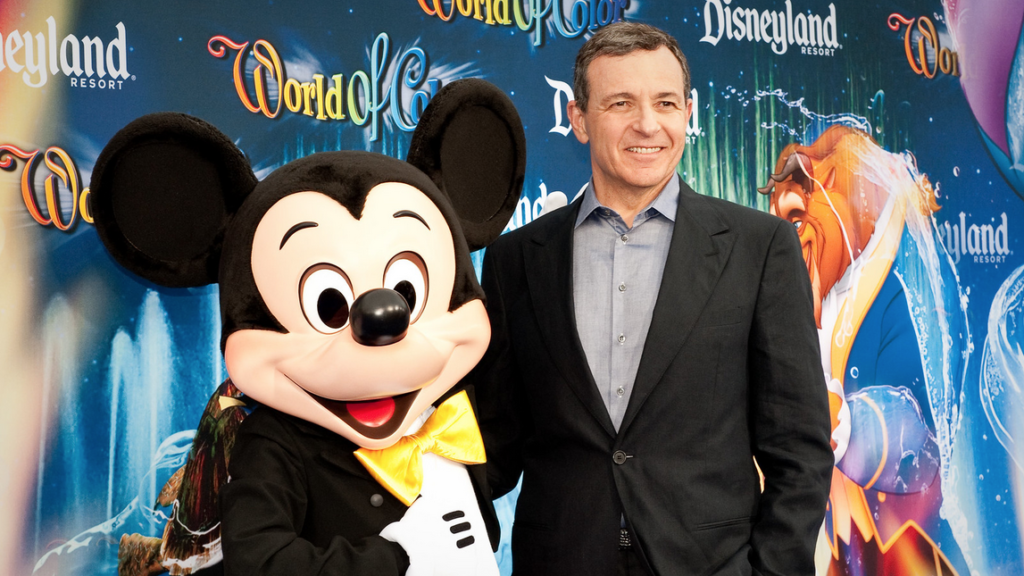 a man in a suit with a mouse mascot