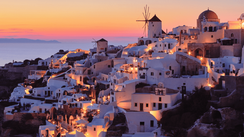 a white buildings with a windmill on the hillside