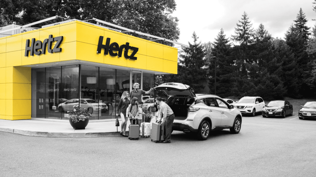 a group of people loading luggage into a car