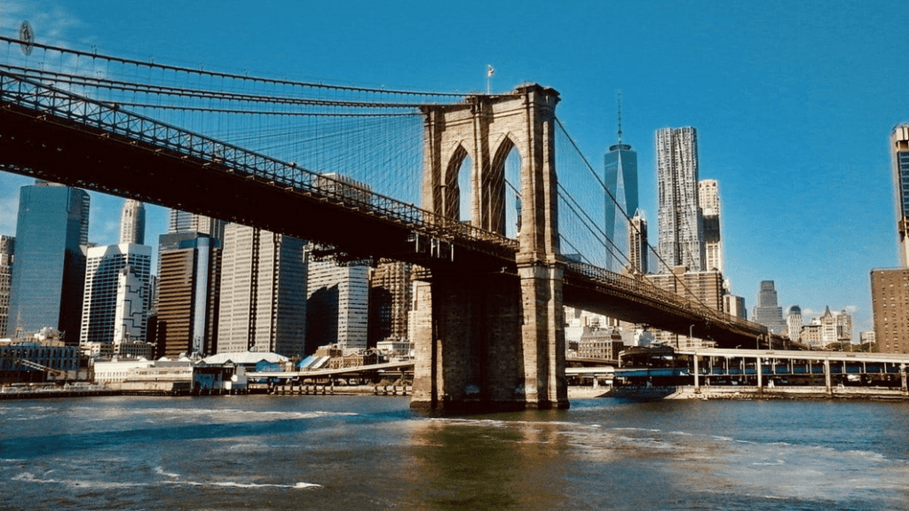 Brooklyn Bridge over water with a city in the background