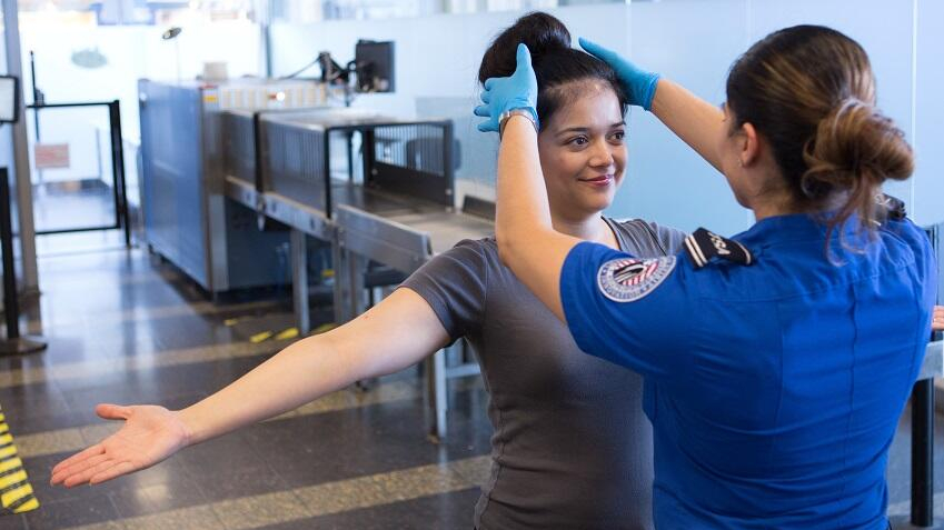 a woman in blue uniform touching a woman's hair