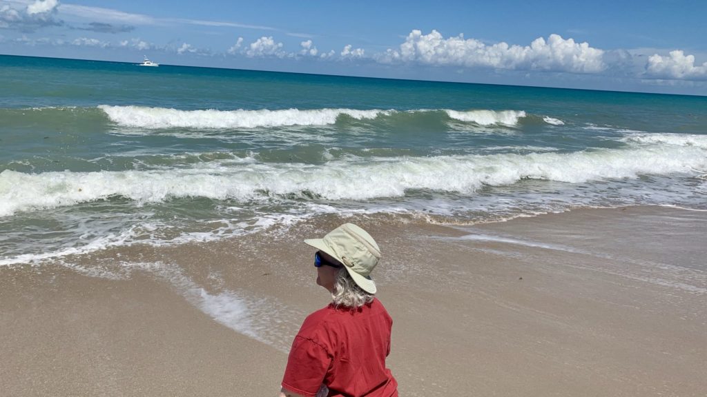 a woman in a hat on a beach