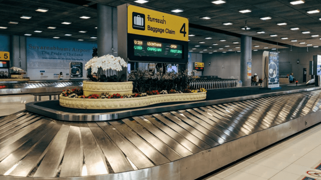 a baggage claim area with a sign and luggage