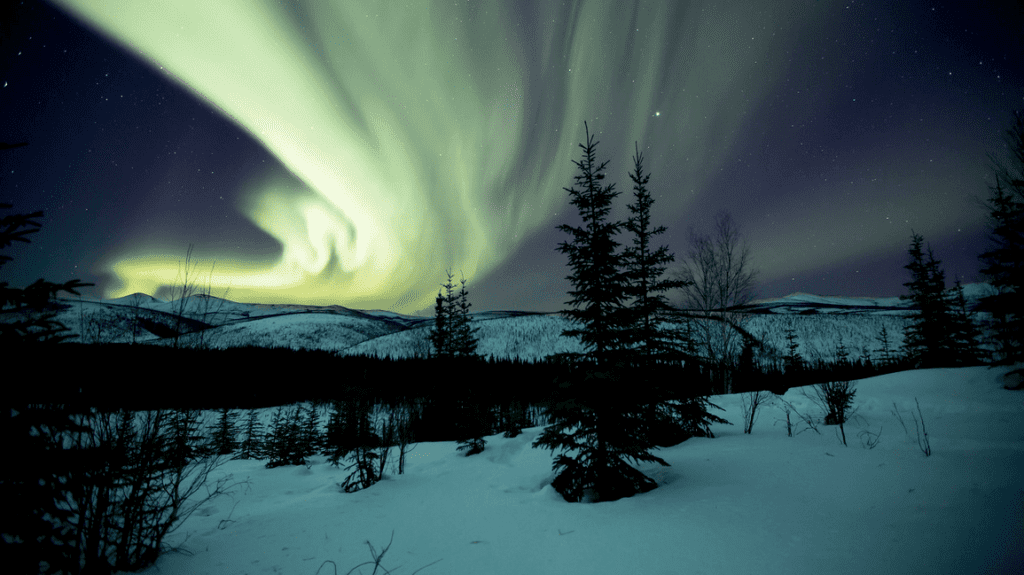 a green lights in the sky over a snowy landscape