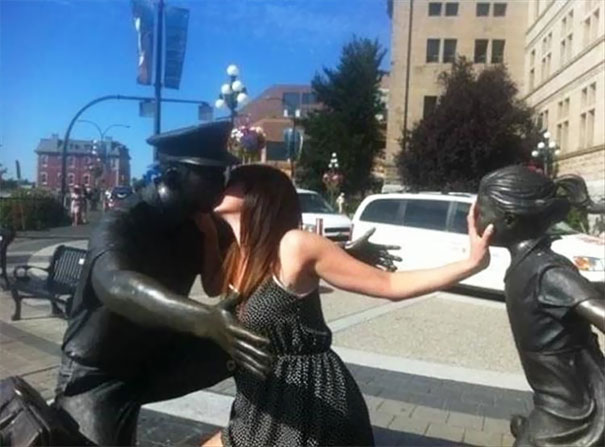 a woman kissing a statue