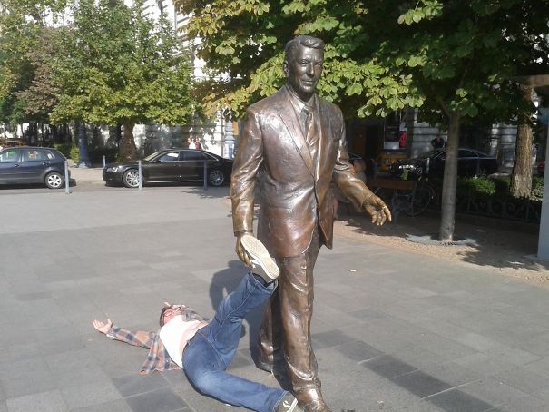 a statue of a man with his leg on the ground