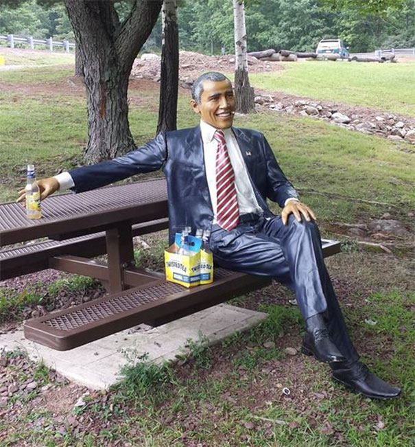a statue of a man sitting on a picnic table