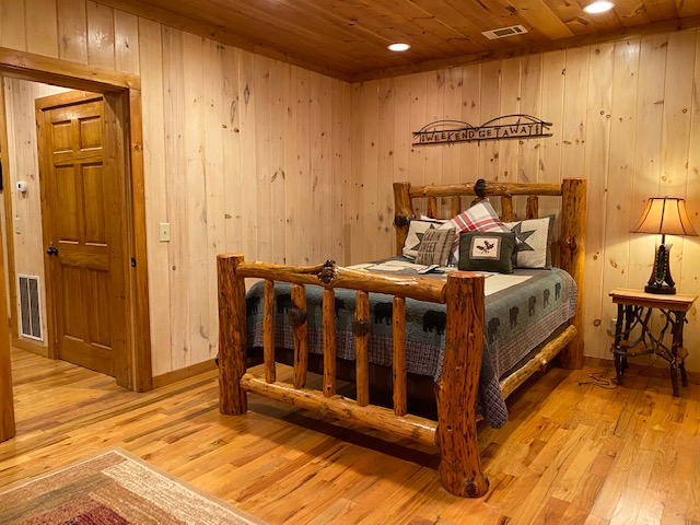 a wooden bedroom with a bed and a door