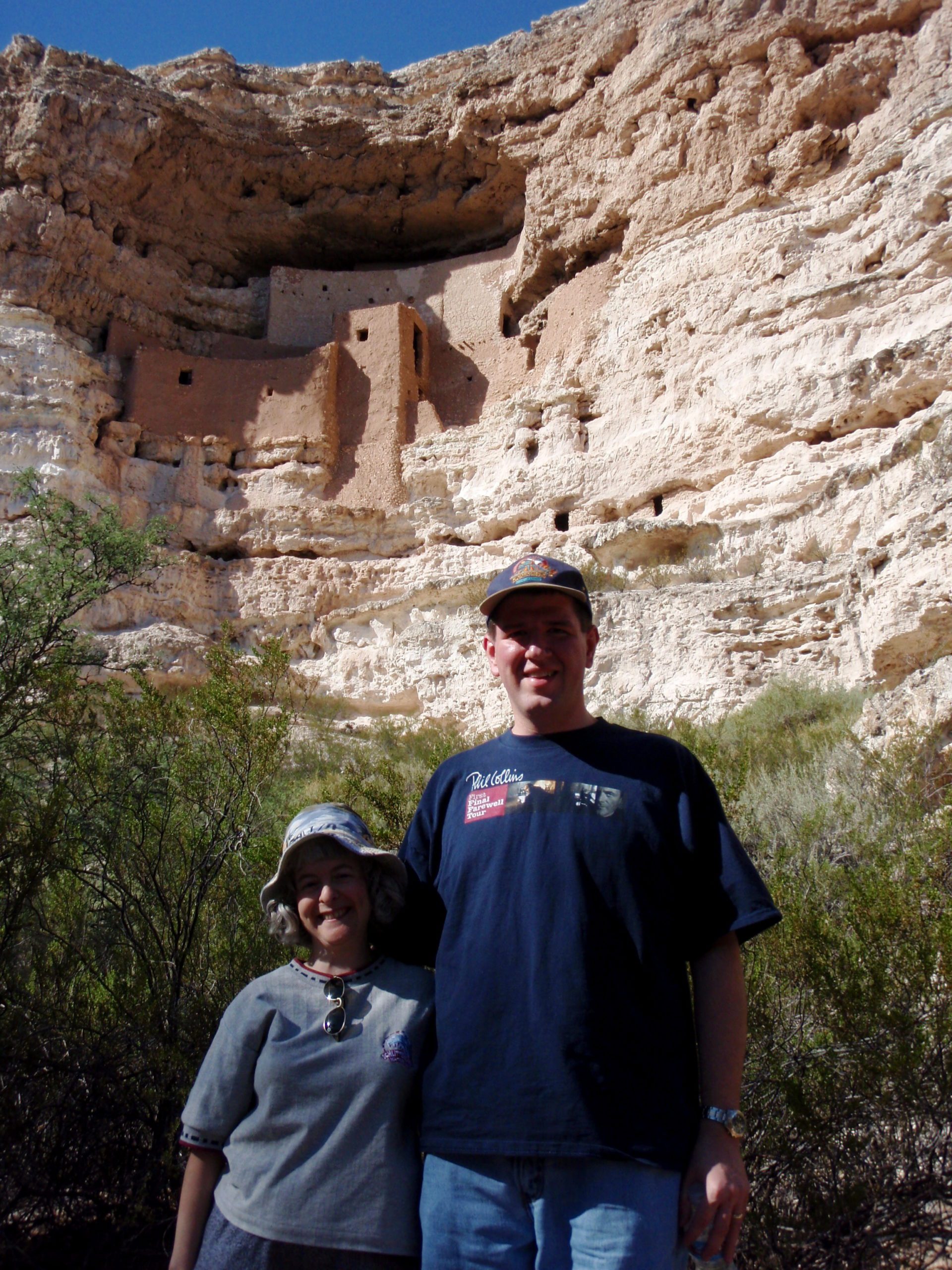 a man and woman standing in front of a cliff