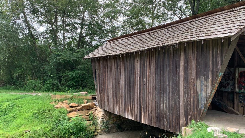 a wooden building with Stovall Mill Covered Bridge over it