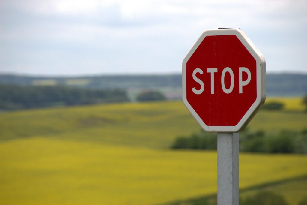 a stop sign with a field of grass in the background