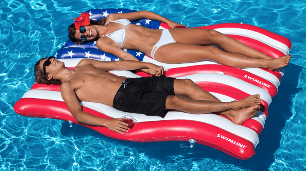 a man and woman lying on a float in a pool