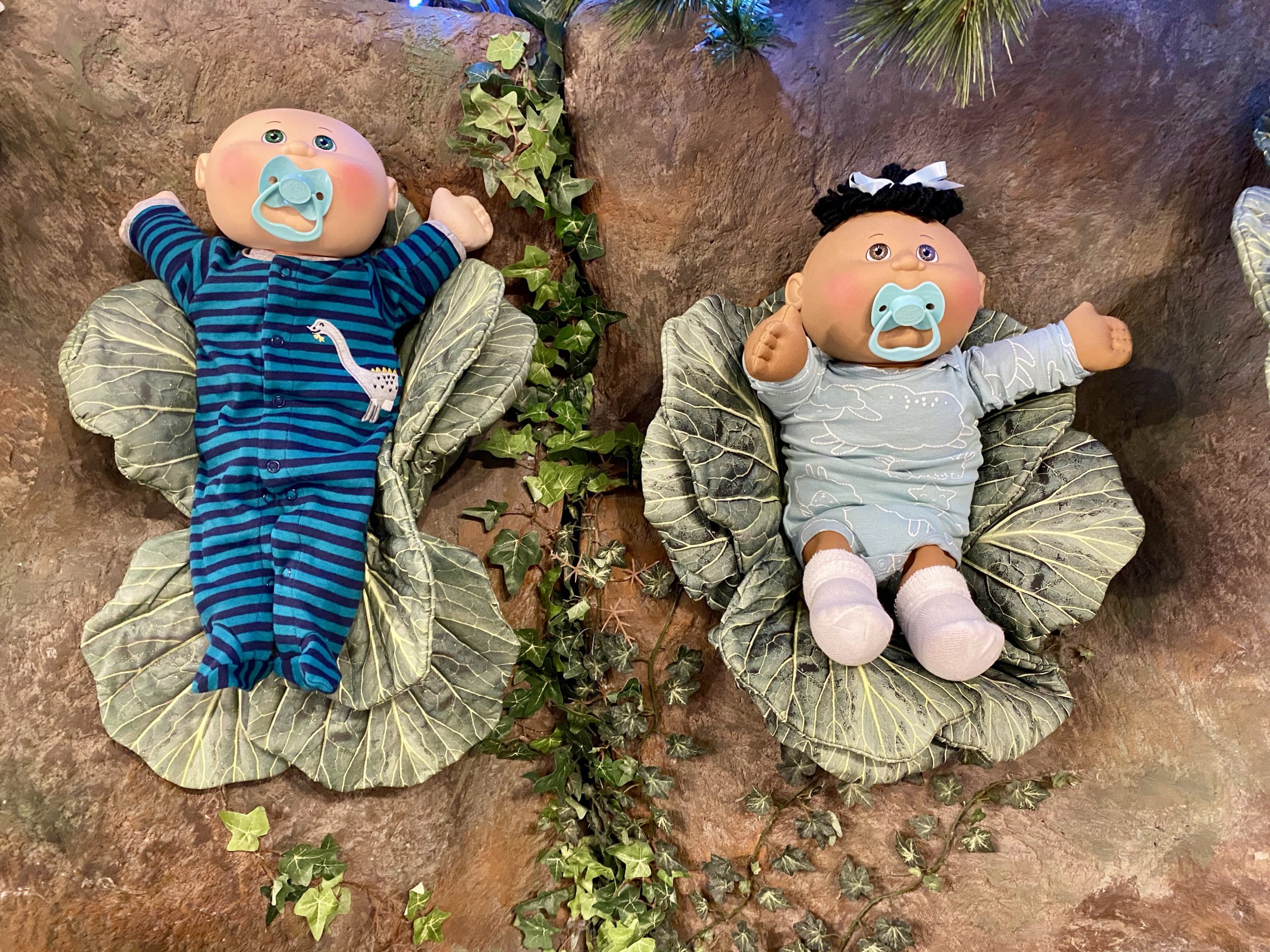 two dolls lying on a rock