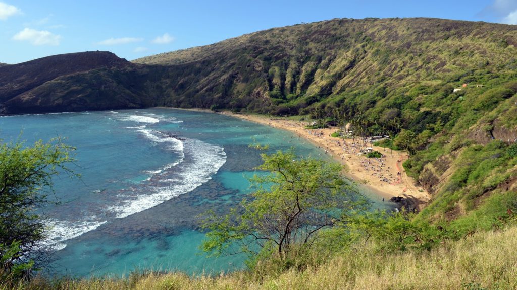 a beach with people and a body of water with Hanauma Bay in the background