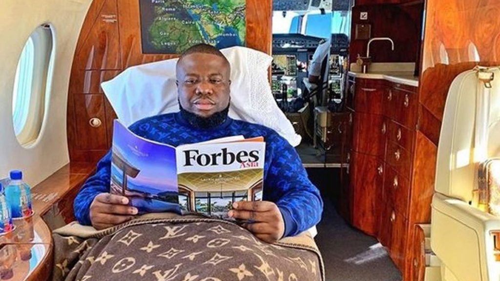 a man lying in a hospital bed reading a magazine