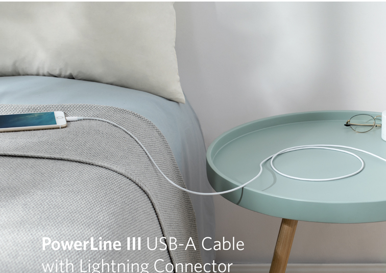 a white cord plugged into a cable on a bed