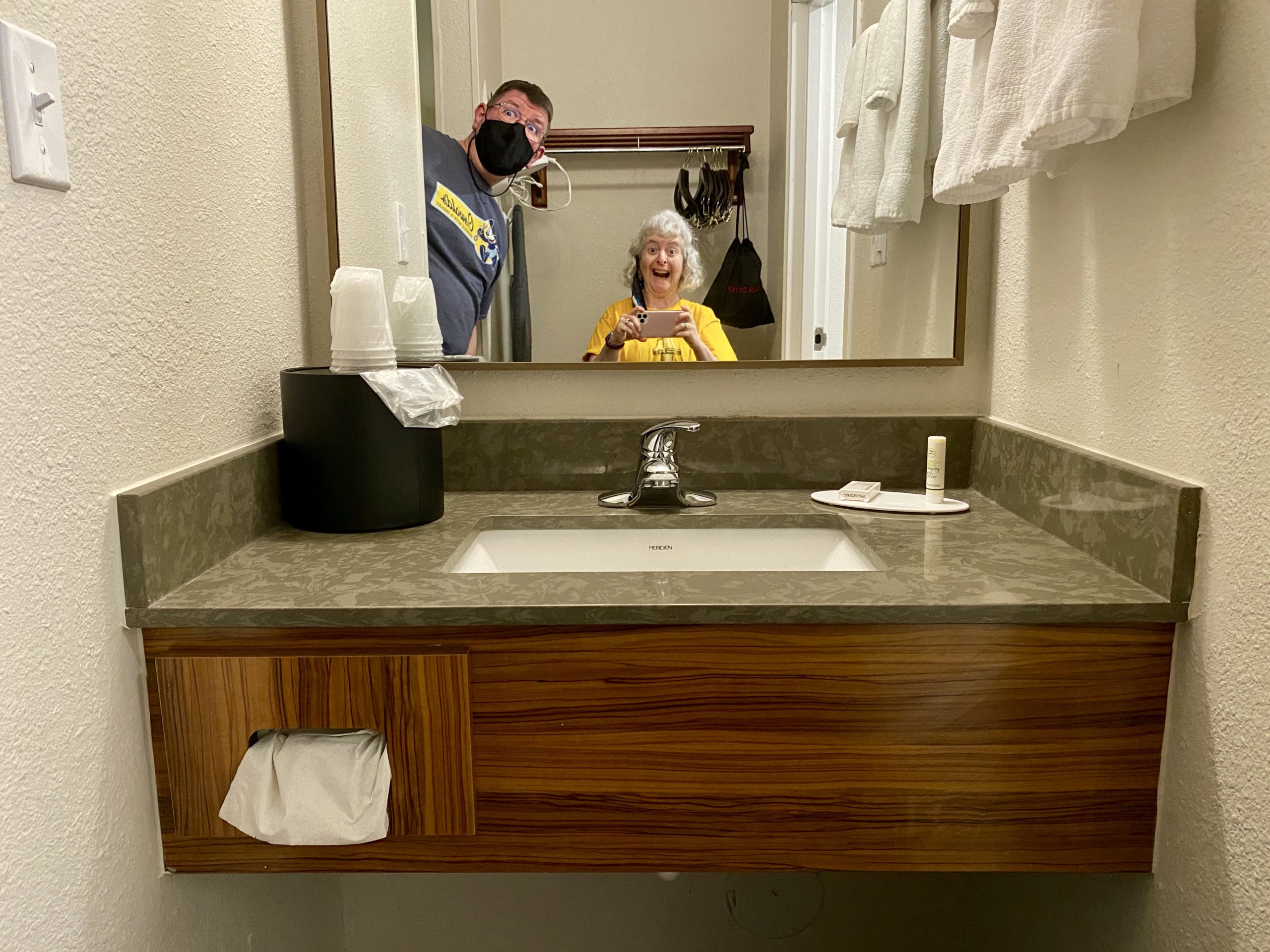 a man and woman taking a selfie in a bathroom