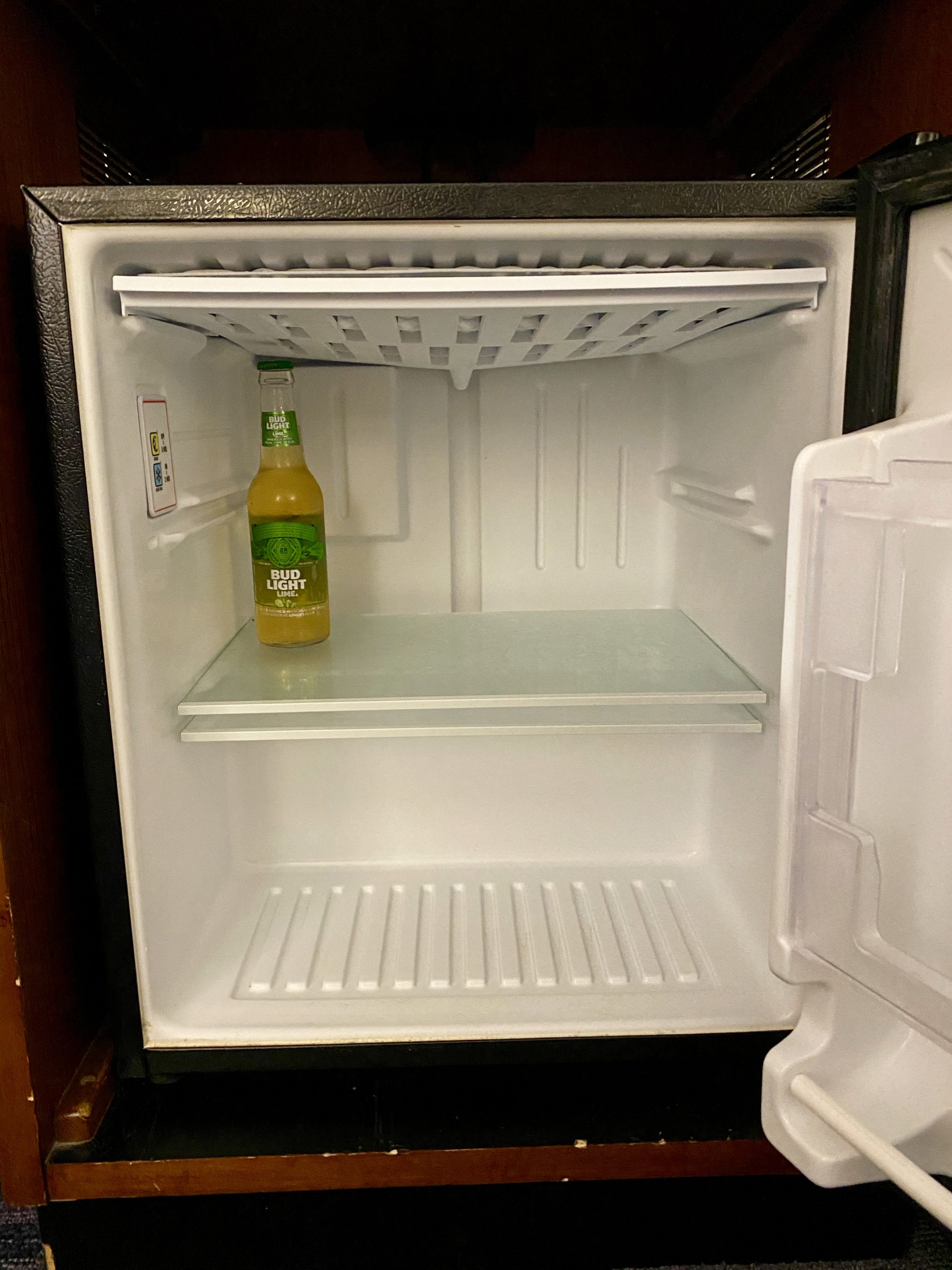 a small refrigerator with a bottle of beer inside