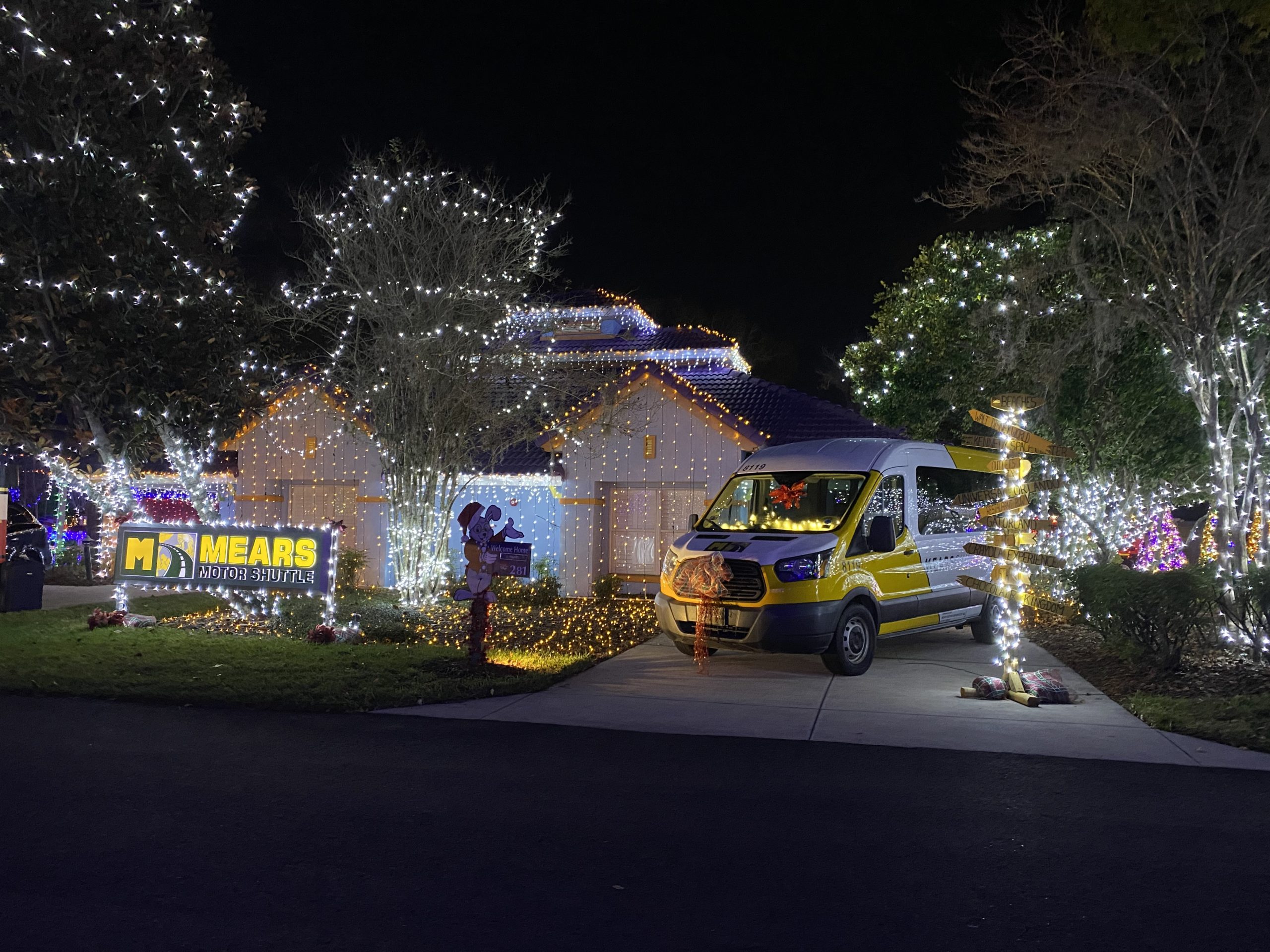 a van parked in front of a house with christmas lights