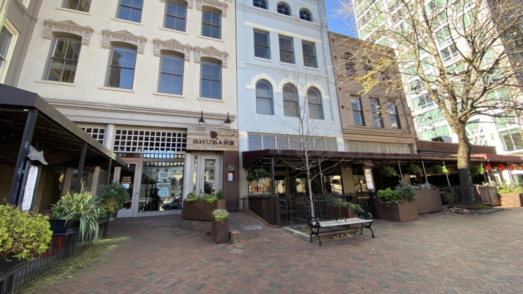 a row of buildings with a bench and a bench in front of them