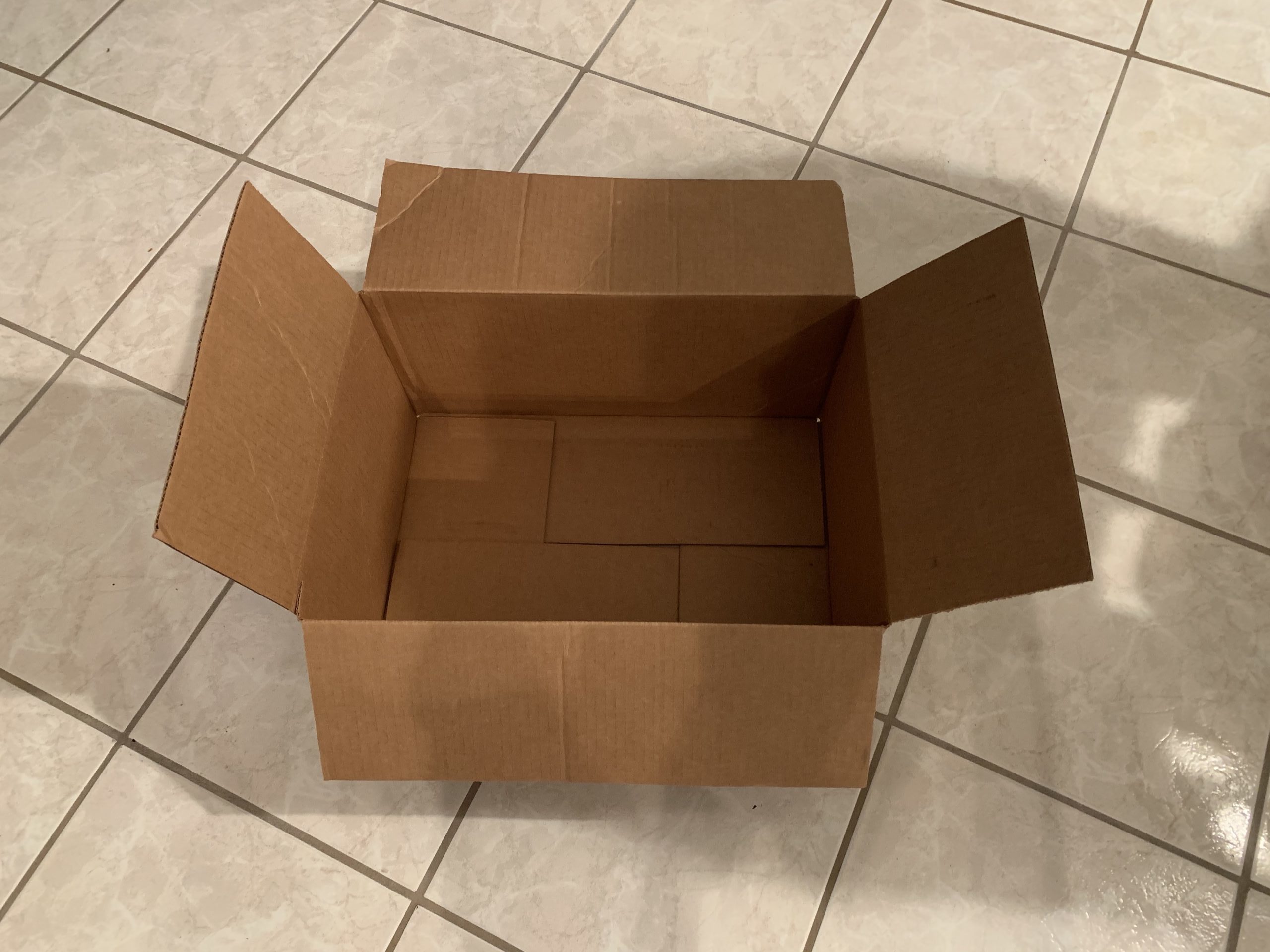 a cardboard box on a tile floor