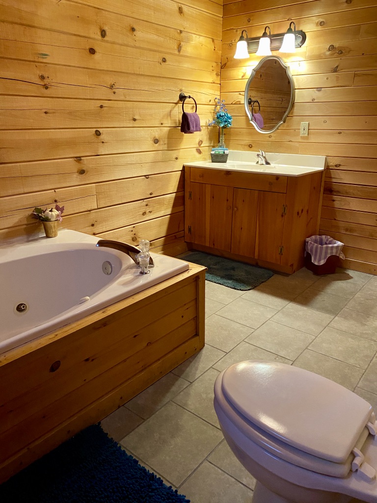 a bathroom with a wooden wall and a tub