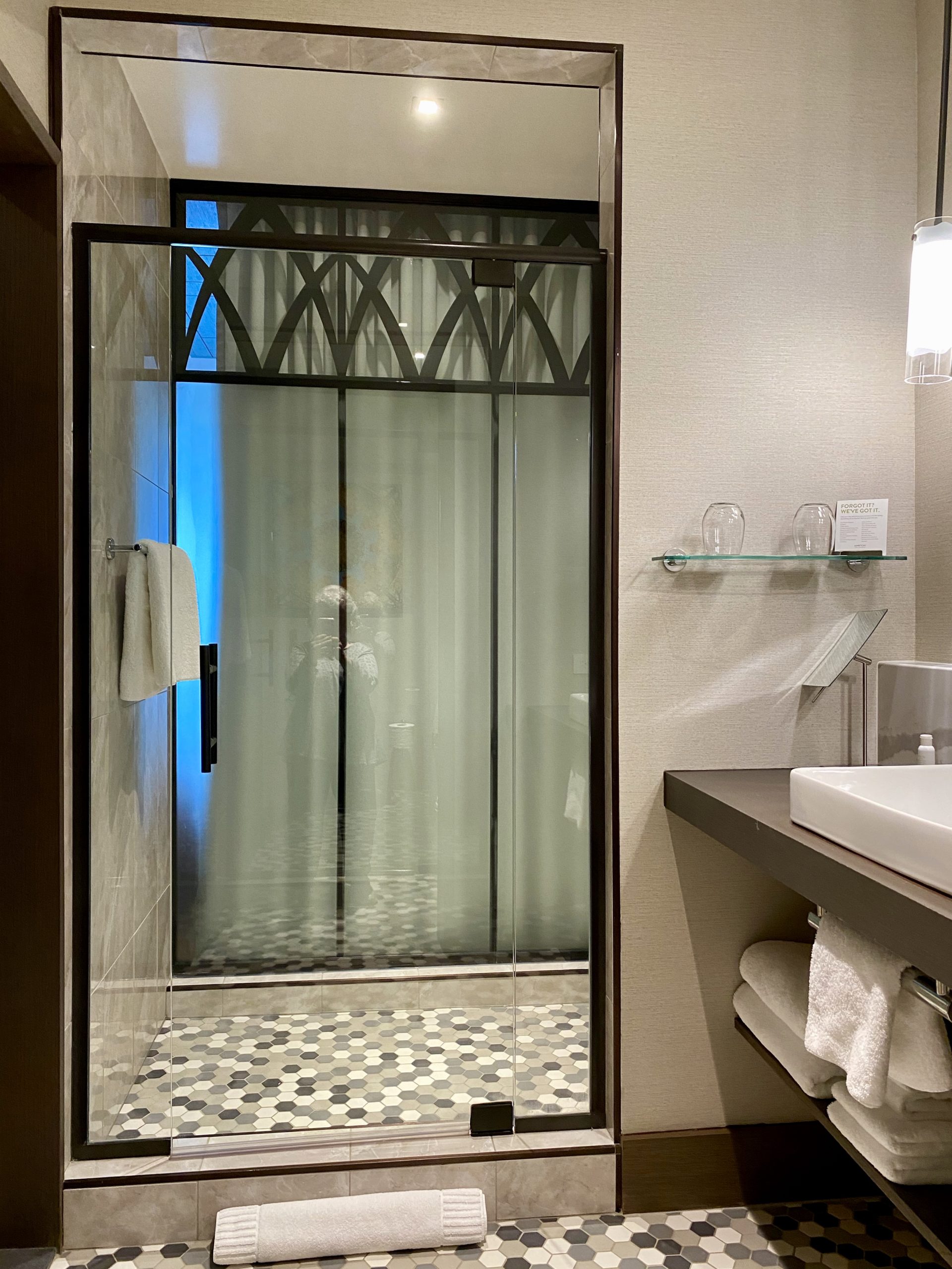 a shower with glass doors and a sink