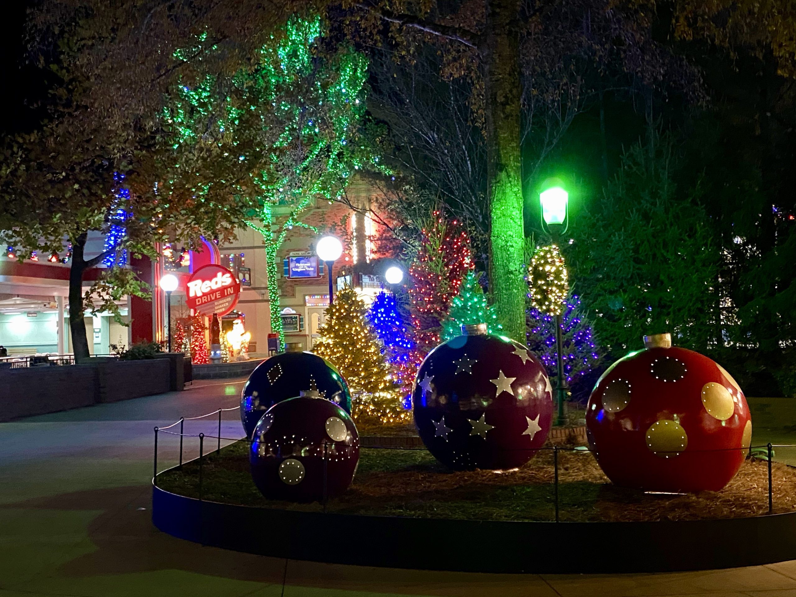 a group of large christmas ornaments in a garden