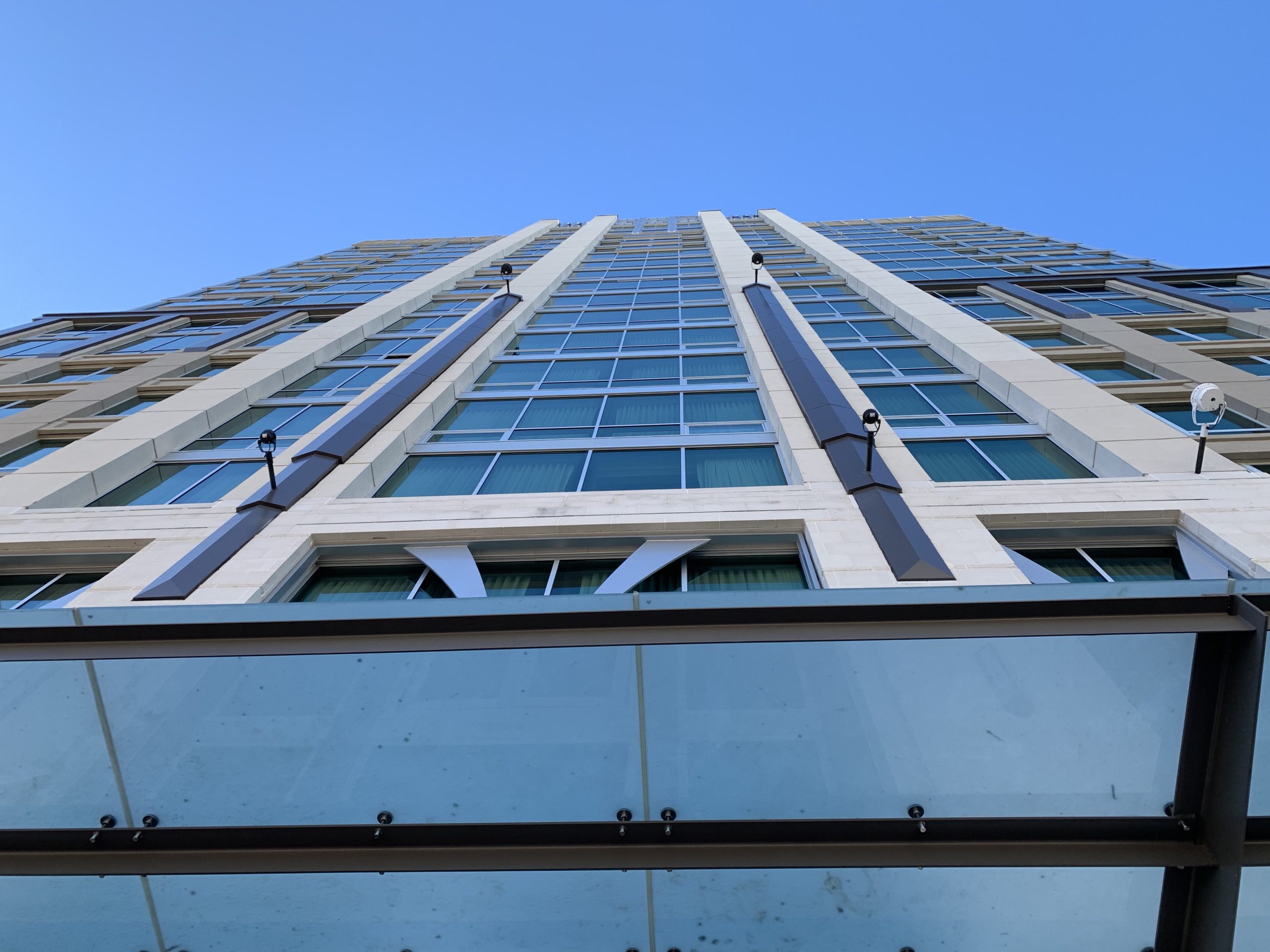 looking up a tall building with glass windows
