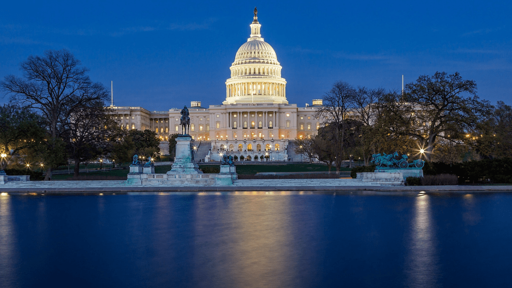 a large white building with a dome and a statue in front of it with United States Capitol in the background