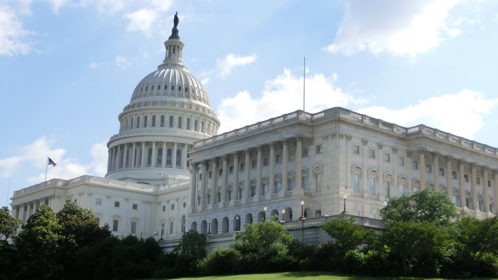 a white building with a dome with United States Capitol in the background