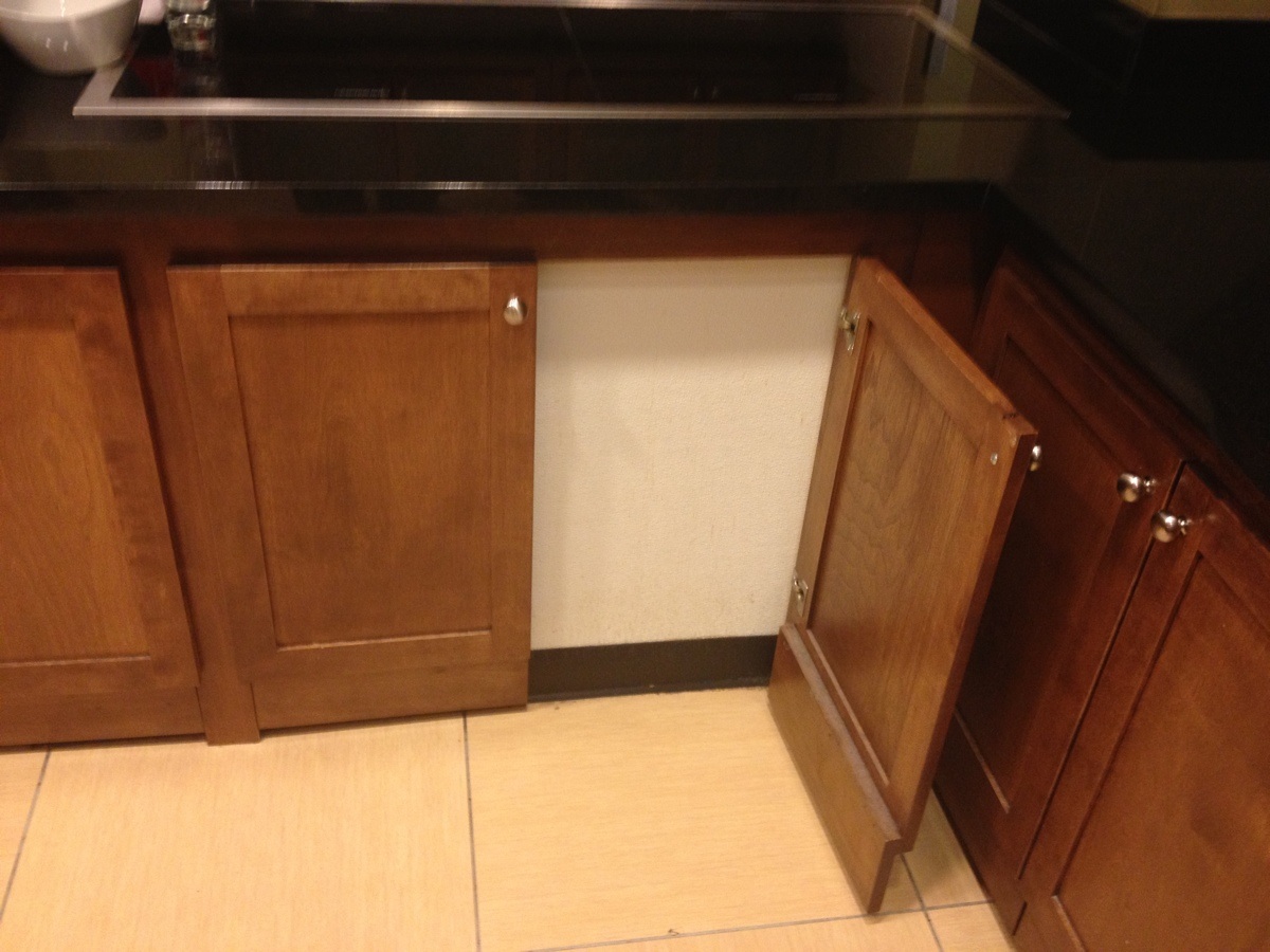 a kitchen counter with a sink and cabinets