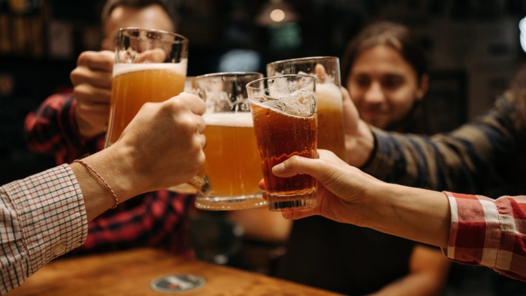 a group of people holding glasses of beer