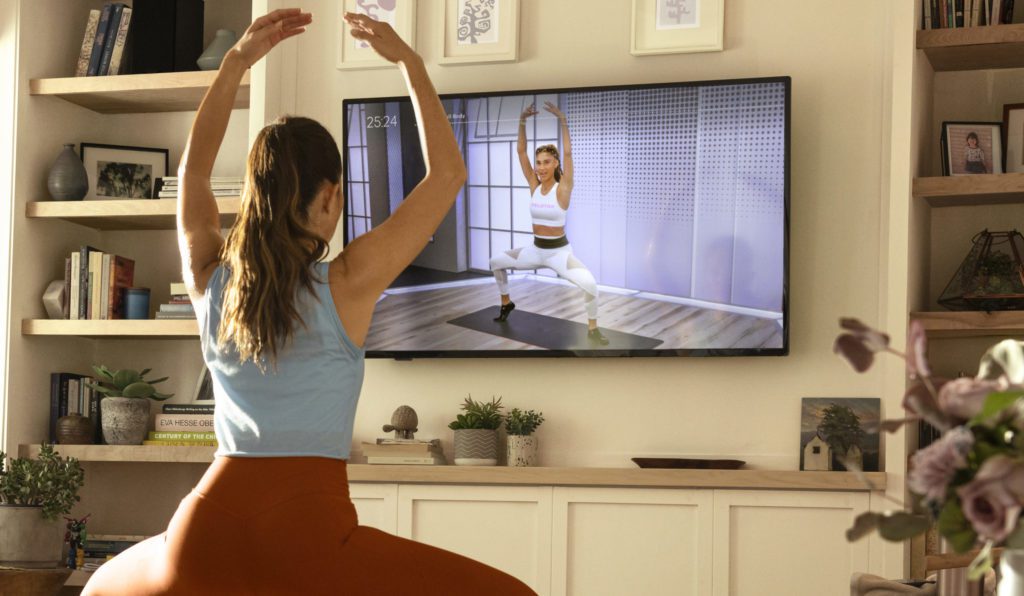 a woman doing yoga in front of a tv