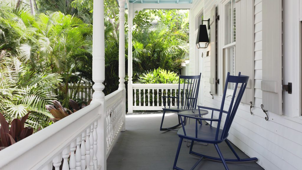 a porch with chairs and a railing