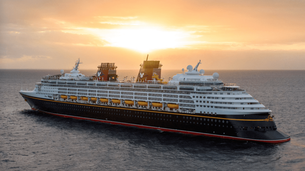 a cruise ship in the water with RMS Queen Mary in the background