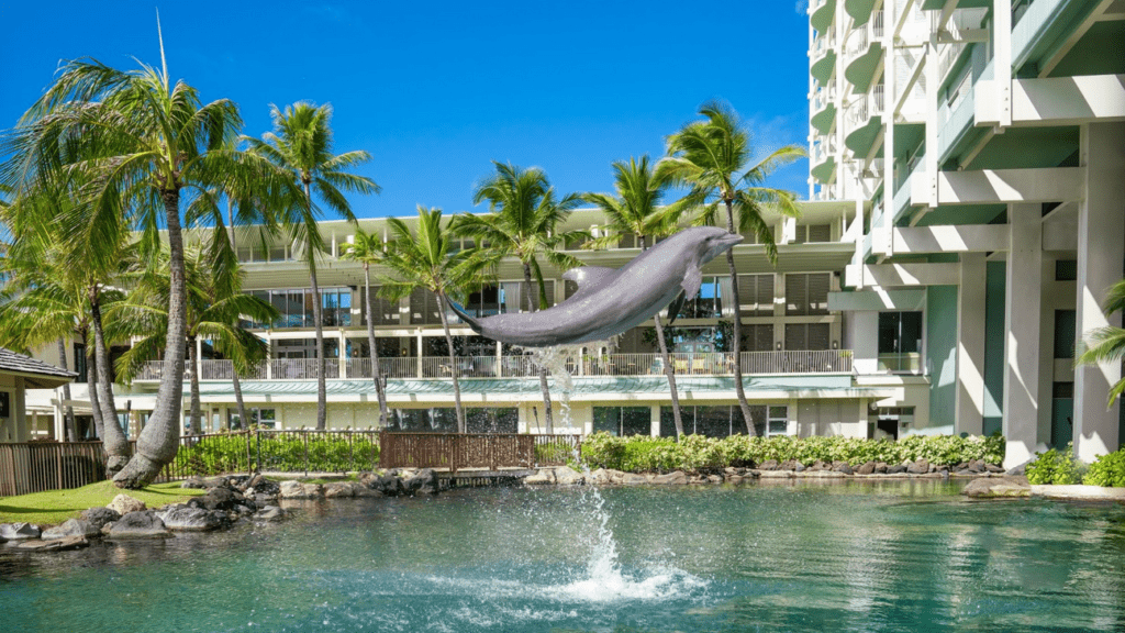 a dolphin jumping out of a pool in front of a building